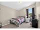 Simple bedroom with a full bed, side table, and desk near the window at 13691 Crystal River Dr, Orlando, FL 32828