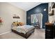 Inviting bedroom with dark blue accent wall, plush bedding, and ample natural light at 13691 Crystal River Dr, Orlando, FL 32828