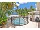 An in-ground swimming pool features a safety fence and is surrounded by tropical plants at 13691 Crystal River Dr, Orlando, FL 32828