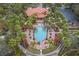 Aerial view of the community pool surrounded by palm trees and lounge areas, showcasing a tropical retreat at 1428 Solana Cir, Davenport, FL 33897