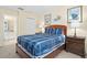Serene bedroom with blue bedding, matching nightstands, nautical decor, and ample natural light at 1428 Solana Cir, Davenport, FL 33897