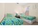 Comfortable bedroom featuring two twin beds with colorful bedding, window, and reading lamp at 1428 Solana Cir, Davenport, FL 33897