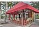 Outdoor covered pool bar with red awning, equipped with seating, refrigerator, and bar counter perfect for entertaining guests at 1428 Solana Cir, Davenport, FL 33897