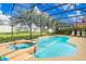 Sparkling pool and in-ground spa surrounded by screened enclosure and green space create a serene outdoor oasis at 1428 Solana Cir, Davenport, FL 33897