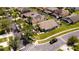 Aerial view featuring mature landscaping, neighborhood streets and screened in pool at 150 Barefoot Beach Way, Kissimmee, FL 34746