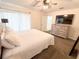 Well-lit bedroom showcases a large bed, dresser with TV, and comfortable carpeting at 150 Barefoot Beach Way, Kissimmee, FL 34746