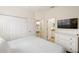 Cozy bedroom featuring a large window, carpet flooring, soft lighting, and ensuite bath at 150 Barefoot Beach Way, Kissimmee, FL 34746