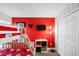 Playful bedroom featuring bunk beds, red accent wall, Mickey Mouse decor, and carpet flooring at 150 Barefoot Beach Way, Kissimmee, FL 34746
