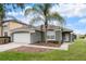 Charming single-story home with a well-manicured lawn and a beautiful palm tree in the front yard at 150 Barefoot Beach Way, Kissimmee, FL 34746