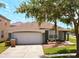Charming single Gathering home featuring a well-maintained lawn, mature landscaping, and a two-car garage at 150 Barefoot Beach Way, Kissimmee, FL 34746