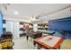 Open-concept game room includes a pool table, air hockey, foosball table, and stylish striped accent wall at 150 Barefoot Beach Way, Kissimmee, FL 34746