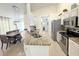 Modern kitchen with stainless steel appliances, granite countertops, and a bright dining area at 150 Barefoot Beach Way, Kissimmee, FL 34746
