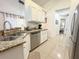 Well-lit kitchen with stainless steel appliances and granite countertops leading into the dining area at 150 Barefoot Beach Way, Kissimmee, FL 34746