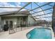 Enclosed pool area with a -safety fence, patio furniture, and view of the home's exterior at 150 Barefoot Beach Way, Kissimmee, FL 34746