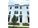 Beautiful three-story townhome featuring white siding, black trim, and well manicured landscaping at 15119 Grove Lake Dr, Winter Garden, FL 34787