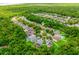 Expansive aerial view of a Gathering-friendly neighborhood with lush trees and manicured lawns with location pin on house at 1646 Song Sparrow Ct, Sanford, FL 32773