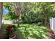Lush backyard featuring mature trees and a well-maintained lawn with a patio seating area at 1646 Song Sparrow Ct, Sanford, FL 32773