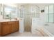Bright bathroom featuring a large walk-in shower, a soaking tub, and a vanity with lots of storage at 1646 Song Sparrow Ct, Sanford, FL 32773