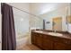 Bathroom featuring double sinks, a large mirror, and a bathtub with a shower at 1646 Song Sparrow Ct, Sanford, FL 32773