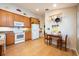 Bright kitchen with tile flooring, wood cabinets, white appliances, and cozy breakfast table in the corner at 1646 Song Sparrow Ct, Sanford, FL 32773