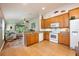 Open concept kitchen featuring tile flooring, wood cabinets, stone countertops, and white appliances at 1646 Song Sparrow Ct, Sanford, FL 32773