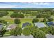 Aerial view of a residential area, showcasing the houses, manicured lawns, and a lake in the distance at 189 Blackstone Creek Rd, Groveland, FL 34736