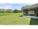 Spacious backyard with green grass, screened lanai, and fence at 189 Blackstone Creek Rd, Groveland, FL 34736