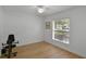 Clean bedroom with a neutral wall color, a window with blinds, and wood-style floors at 189 Blackstone Creek Rd, Groveland, FL 34736