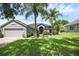 Well-kept home featuring lush landscaping and a manicured green lawn with two palm trees at 189 Blackstone Creek Rd, Groveland, FL 34736