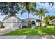 Charming single-story home with a well-manicured lawn and lush palm trees at 189 Blackstone Creek Rd, Groveland, FL 34736