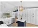 Modern kitchen with stainless appliances, an island, white cabinets, and an open floor plan at 189 Blackstone Creek Rd, Groveland, FL 34736