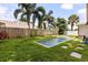 Backyard with rectangular pool, surrounded by lush greenery and a wooden fence at 1891 Bryan Ave, Winter Park, FL 32789