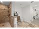 Luxurious bathroom with a walk-in shower, tiled walls, travertine floors, and a stylish vanity with ample storage at 1891 Bryan Ave, Winter Park, FL 32789