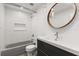 Modern bathroom featuring a sleek vanity, round mirror, and shower with stylish subway tile and a built-in niche at 1891 Bryan Ave, Winter Park, FL 32789