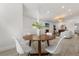 Open-concept dining area with modern lighting and a view of the living room's fireplace and bright, neutral decor at 1891 Bryan Ave, Winter Park, FL 32789