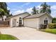 Attractive home exterior featuring an attached garage, arched windows, and lush landscaping in a green neighborhood at 1891 Bryan Ave, Winter Park, FL 32789