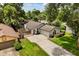 Charming single-story home with a well-manicured lawn and a long driveway in a lush, green neighborhood at 1891 Bryan Ave, Winter Park, FL 32789
