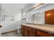 Bathroom features a vanity with wood cabinets, a toilet, and a large mirror at 19 Hemlock Terrace Way, Ocala, FL 34472