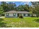 Charming single-story home featuring a well-maintained lawn, complemented by a green door and blue shutters at 19 Hemlock Terrace Way, Ocala, FL 34472