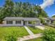 Inviting single-story home with lush green lawn, a walkway, and mature trees at 2109 Hartwell Ave, Sanford, FL 32771