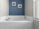 Relaxing bathroom featuring a corner soaking tub, tile surround, and ocean-themed artwork at 2222 Wyndham Palms Way, Kissimmee, FL 34747