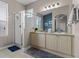 Bright bathroom featuring double sinks, a glass-enclosed shower, and tile flooring at 2222 Wyndham Palms Way, Kissimmee, FL 34747