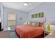 Bright bedroom featuring an accent wall, a ceiling fan, and a comfortable bed with tropical-themed pillows at 2222 Wyndham Palms Way, Kissimmee, FL 34747