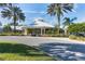 Beautiful clubhouse entrance with manicured landscaping, palm trees, and circular driveway at 2222 Wyndham Palms Way, Kissimmee, FL 34747