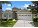 Charming home featuring a two-car garage, well-maintained lawn, and beautiful landscaping at 2222 Wyndham Palms Way, Kissimmee, FL 34747