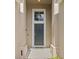 Charming front entrance with a stylish gray door, decorative window, and a welcoming door mat at 2222 Wyndham Palms Way, Kissimmee, FL 34747