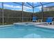 Heated pool with attached spa and lush landscaping in a screened enclosure at 2222 Wyndham Palms Way, Kissimmee, FL 34747