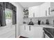 Modern kitchen featuring white cabinets, sleek countertops, black hardware and stainless steel appliances at 224 Woodmere Blvd, Sanford, FL 32773