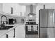 Stylish kitchen featuring white cabinets, stainless steel appliances, and modern fixtures at 224 Woodmere Blvd, Sanford, FL 32773