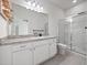 Bright bathroom with white cabinetry, countertop space, and tiled shower and a door to the bedroom at 2249 Litchfield Loop, Deland, FL 32720